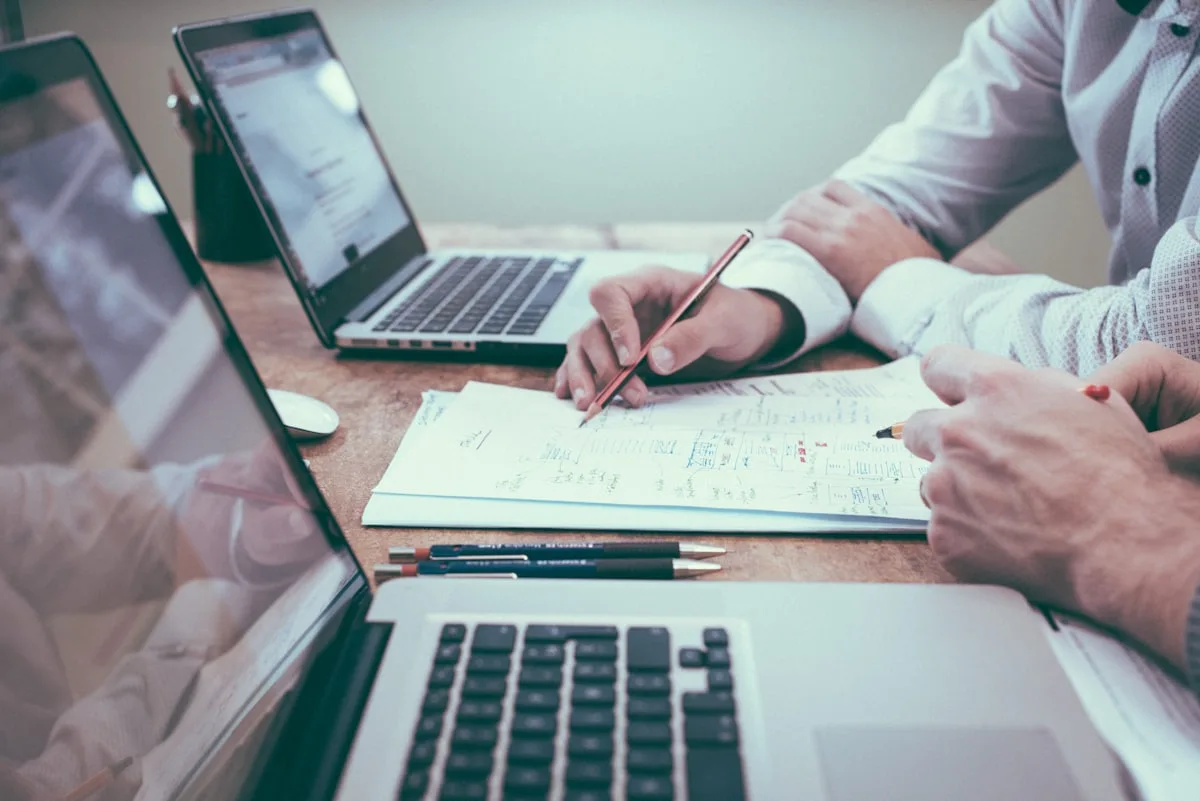 Accountants reviewing figures on paper and a laptop