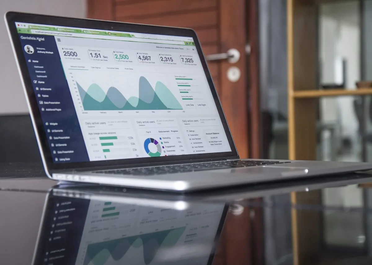 A laptop showing a financial dashboard with charts